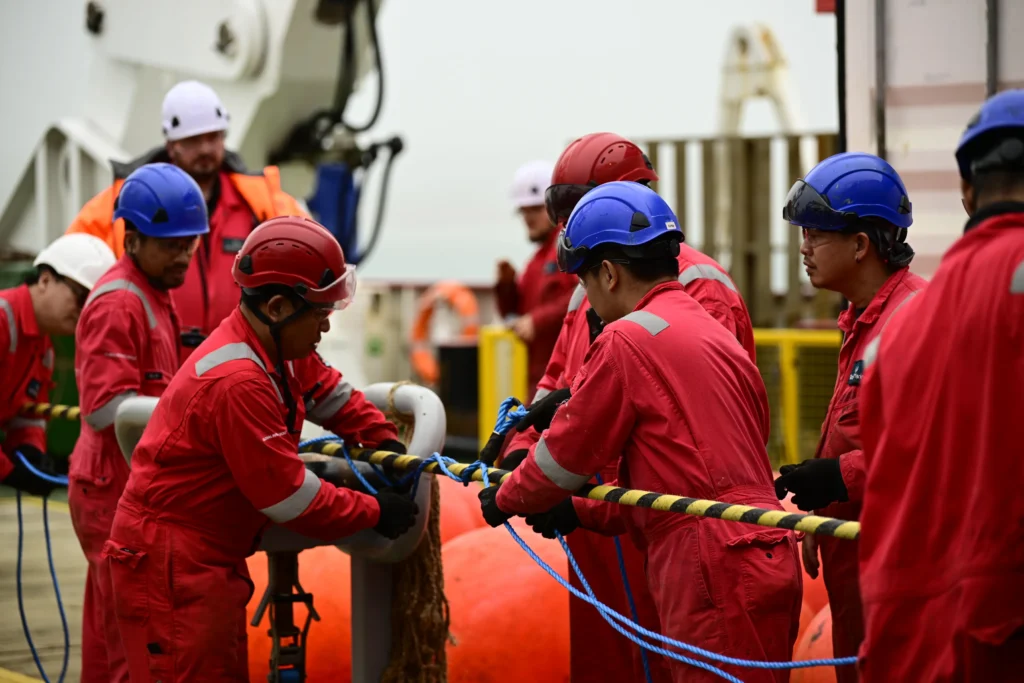 Vessel crew working on subsea cable at sea